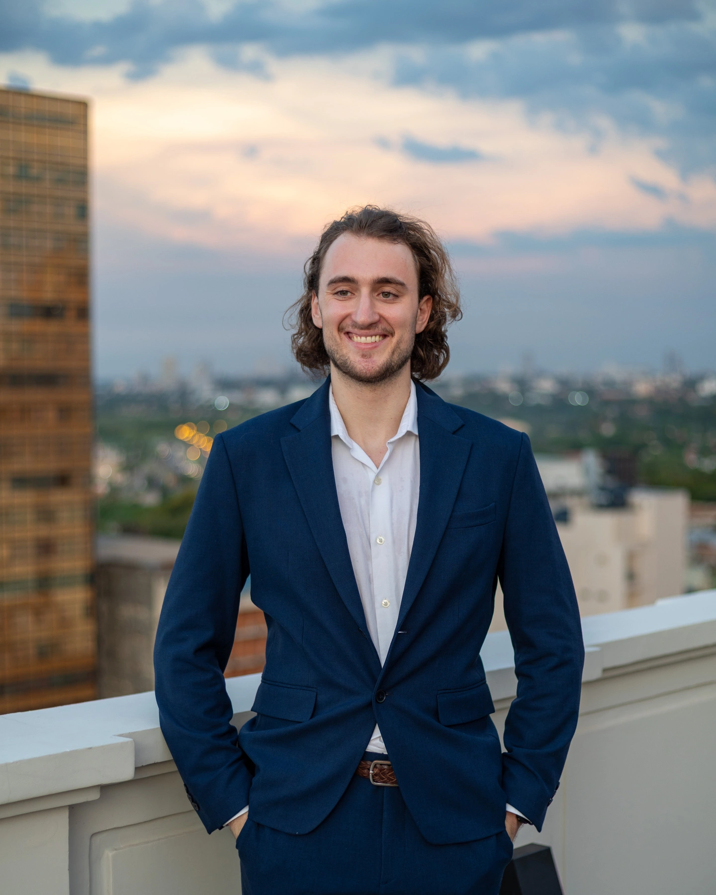 Client in a fitted suit on a rooftop at golden hour